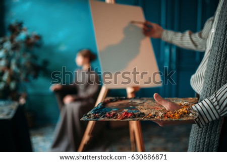 Male painter paints womans portrait
