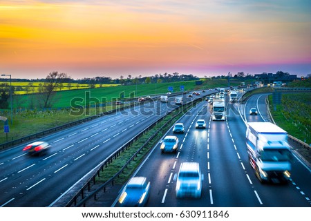 Colourful sunset at M1 motorway near Flitwick junction with blurry cars in United Kingdom. Royalty-Free Stock Photo #630911846