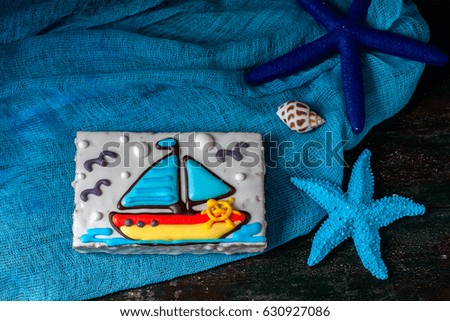 Homemade homemade gingerbread cookie in the shape of a boat on the dark dark wooden background. Selective focus.