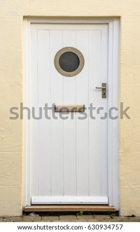 Interesting entrance to the building, white door with bull's eye and mailbox, sailing elements