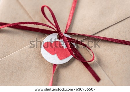 top view of kraft envelope with tag with two hearts and ribbon, wedding invitation card concept