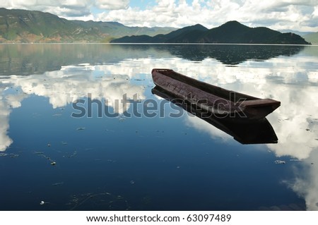 Scenic view of mountain lake with boat at countryside