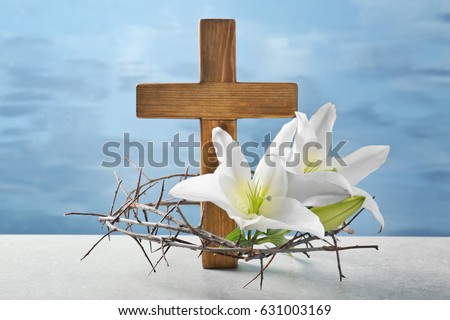 Crown of thorns, wooden cross and white lily on table
