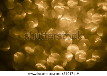 Abstract gold glitter lights on golden background. Round defocused circles bokeh and shine glitters bright light. Template for design