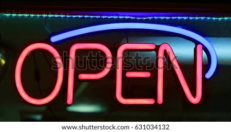 Retro glowing neon sign that says open 