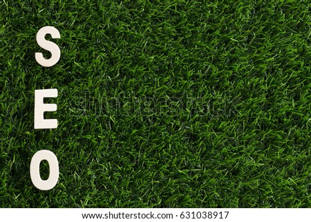 Wood Letters was Arranged vertical as SEO Abbreviation (Search Engine Optimization) on Artificial Green Grass. Copy Space for Text. Idea Concept for Organization, Business, Technology System.