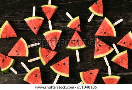 watermelon slice popsicles on a rustic wood background