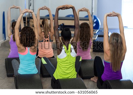 Rear view of women exercising on arc barrel in gym