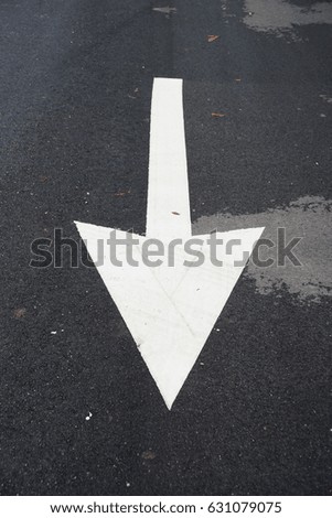 Asphalt road. Arrow sign on asphalt