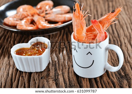 Happy cup with boiled shrimps and spicy sauce on the wooden table. Concept about love and relationship