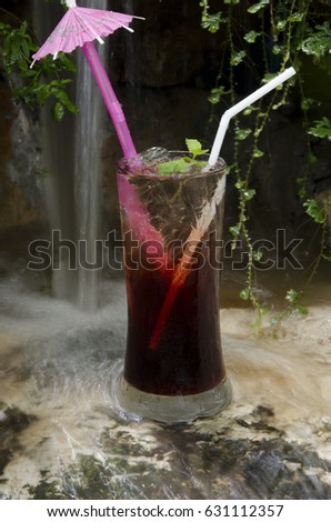 Freshness fruit juice with waterfall background.