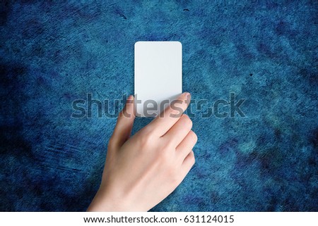 Woman hand holding Blank business card for mock up, present over Dark Blue Grunge background
