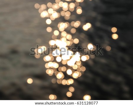 gold blurred bokeh background light with warm tone sunset in evening, blur river defocused concept, soft focus golden bubble textured and glitter shiny xmas on black background