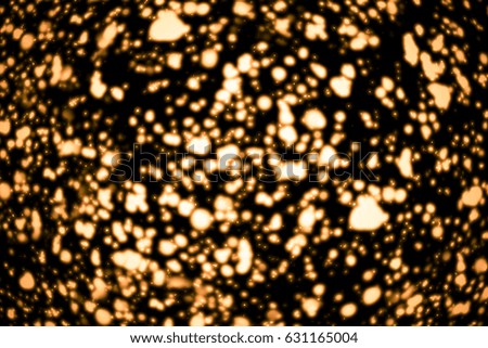 Golden abstract sparkles or glitter lights. Festive gold background. Defocused circles bokeh or particles. isolated on black. Template for design
