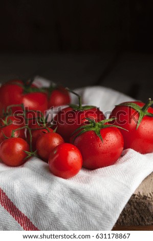 
Ripe tomatoes on a branch of a white napkin, dark background.