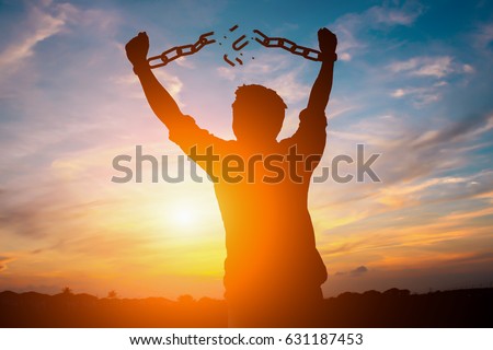 Silhouette image of a businessman with broken chains in sunset. Royalty-Free Stock Photo #631187453