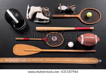 Different vintage sports equipment on black background surface, studio shot from above
