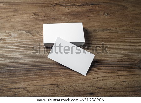 Photo of blank business cards on a wooden table background. Template for ID.