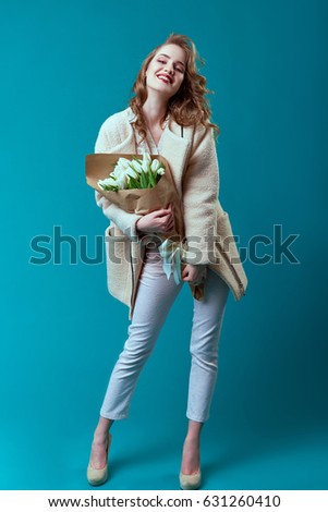 Beautiful young woman in studio with a bouquet of flowers