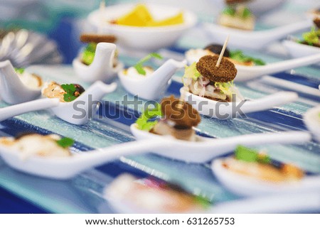 Catering services during events and holidays. Light snacks and canaps, seafood, shrimp, olives on Japanese spoons for miso soup. Soft selective focus and beautiful bokeh.