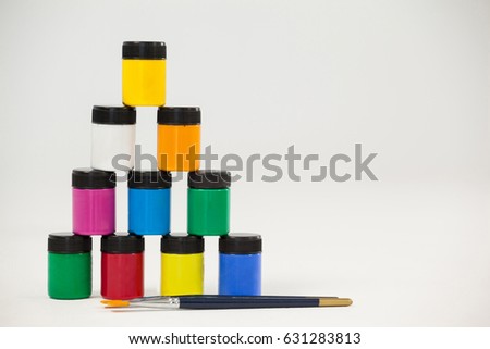 Pyramid of watercolor paints and paint brushes against white background