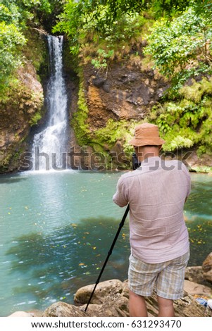Photographer taking photo of The Chamouze waterfall. Mauritius island