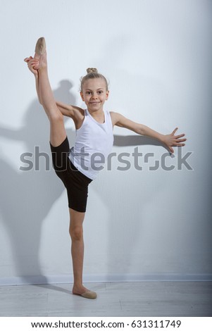 little girl gymnast in studio gray background