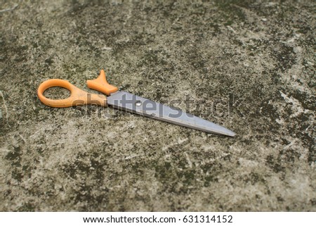 Old scissors on the rough concrete
