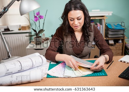 Professional architect woman in her office with color cards in front of her. Architecture and construction. Color pallete