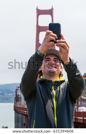 Man taking selfies of Golden Gate Bridge, San Francisco USA