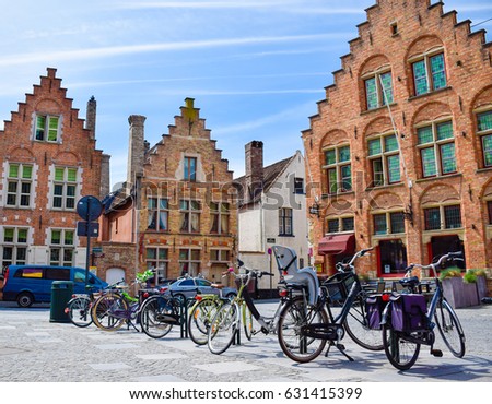 Bicycles are parked in front of historical medieval brick buidlings