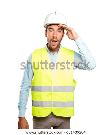 Astonished engineer with search gesture against white background
