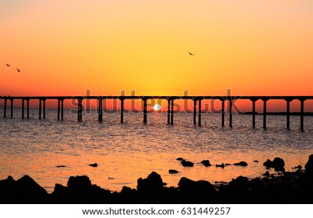 Sunrise landscape, sea with bridge and orange sky background
