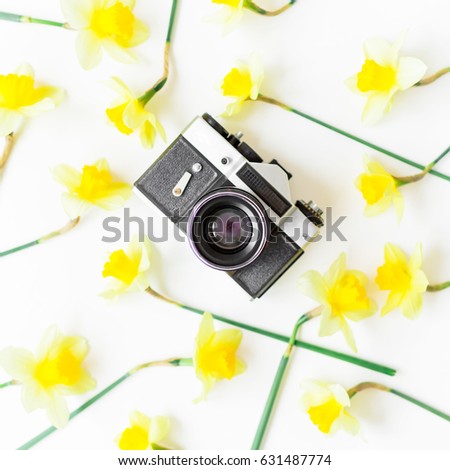 Vintage retro camera and yellow flowers on white background. Flat lay. Top view.