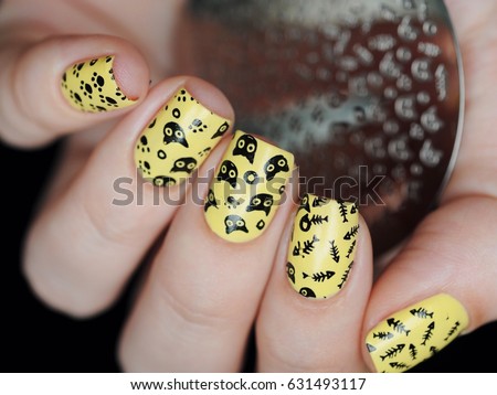 Cute yellow manicure with cats and a fish skeleton