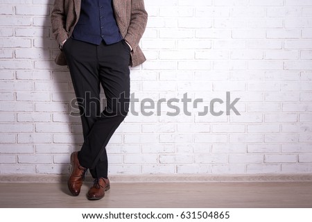 male fashion concept - close up of male legs in business suit and shoes over brick wall Royalty-Free Stock Photo #631504865