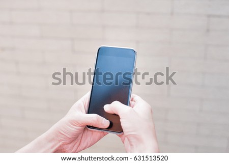 Woman using smart-phone on block background
