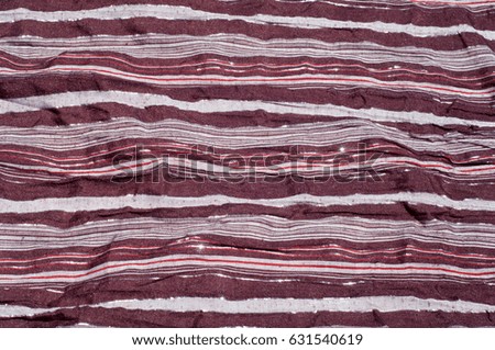 Texture, background, pattern. Female striped scarf, cloth striped brown, white, red with glitter