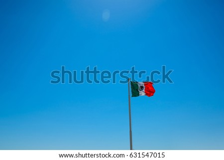 Giant mexican flag flies in the wind in Cancun. Shot in Yucatan, Mexico