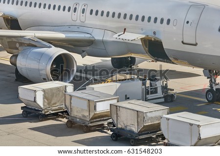 Cargo containers loaded into an airliner Royalty-Free Stock Photo #631548203