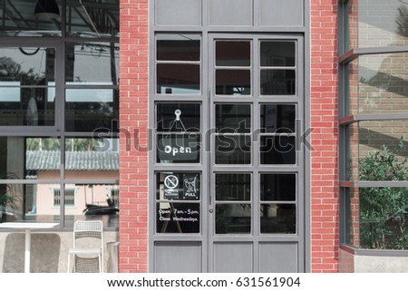 gray iron doors with glass and red brick.and sign 