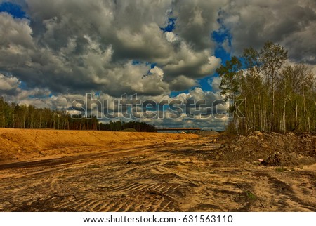 A view from above for the construction of a highway leading through the forest.Poland in april.Photography in HDR technique using special filters. Horizontal view. Royalty-Free Stock Photo #631563110