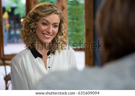 Smiling young woman looking at man in coffee shop