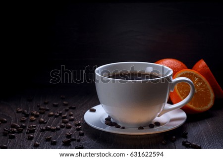 coffee cup with orange to the wood table on black background