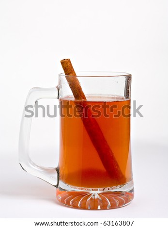 Hot apple cider in clear glass with cinnamon stick