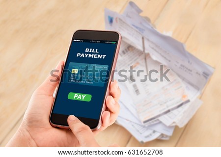 Online bill payment concept.Hands holding mobile phone on blurred Electric bill as background Royalty-Free Stock Photo #631652708