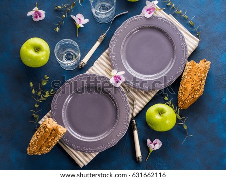 Empty gray plates served for lunch with flowers and herbs. Spring summer healthy meal concept