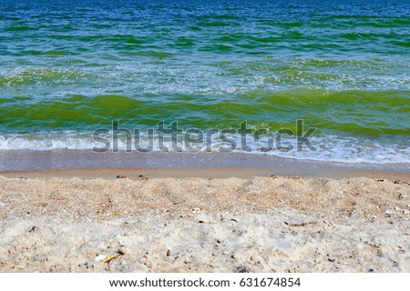 Soft sea ocean waves wash over golden sand background. Beautiful seascape with water splashes. Selective focus on the splash