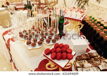 stylish candy bar with sweets and drinks at luxury wedding reception. catering at restaurant. cupcakes pops macaroons and juice cocktails lemonade on table. space for text