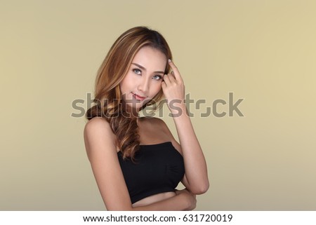 Beautiful Clear Clean Skin Woman straight brunette brown hair with Smooth pose black strapless bra, studio lighting pastel yellow background